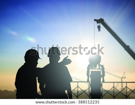 silhouette man survey and civil engineer stand on ground working in a land building site over Blurred construction worker on construction site. examination, inspection, survey