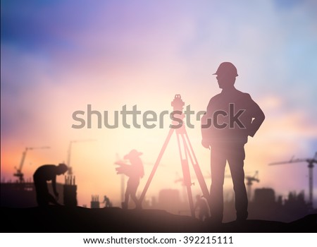 Silhouette Successful male engineer standing survey work on construction over blurred high-voltage pylons and construction. examination, inspection, survey