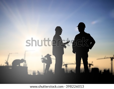 Silhouette Successful male engineer standing survey work on construction over blurred Worker in  construction site over blurred nature. examination, inspection, survey