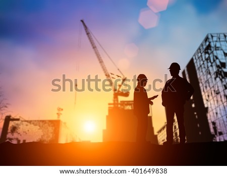 silhouette young engineer working construction standards in line with global construction environment and the environment around the work site. over Blurred construction worker on construction site