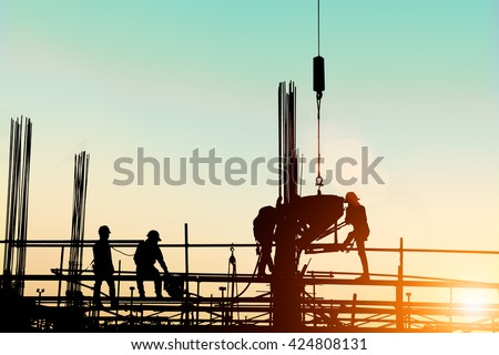 Silhouette construction industry engineer standing orders for construction team to work safely on high ground over blurred background sunset pastel for industry background. heavy industry concept.