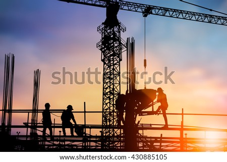Silhouette engineer standing orders for construction crews to work safely on high ground over blurred natural background sunset pastel. heavy industry and safety at work concept.