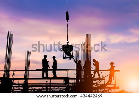 Silhouette engineer standing orders for construction crews to work safely on high ground over blurred natural background sunset pastel. heavy industry and safety at work concept.