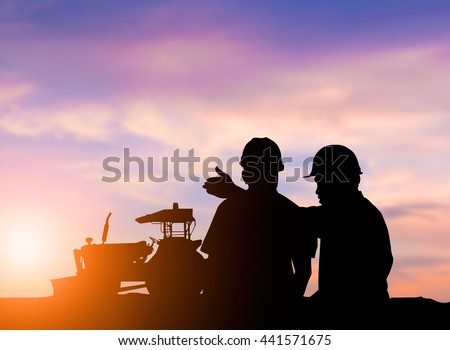 silhouette two men to operate heavy machinery plowed soil in preparation for planting crops. The main industry of the world. concept food crop. concept to save the world.