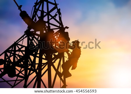 Silhouette Business Industrial Electrician for the installation of electrical systems for alternative energy over blurred pastel background sunset.Heavy industry and Transportation and People concept.