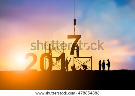 Silhouette employees work as a team to change the 6 to 7 prepared to welcome the New Year over blurred sunset. Teamwork, success, Industry, Business, People, engineers, working a systematic concept.