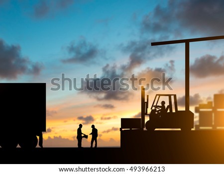 Silhouette inspector are examining the waybill with the Forklift. truck bringing up the goods in warehouses over blurred natural background sunset pastel.Business Logistics and Transportation concept.
