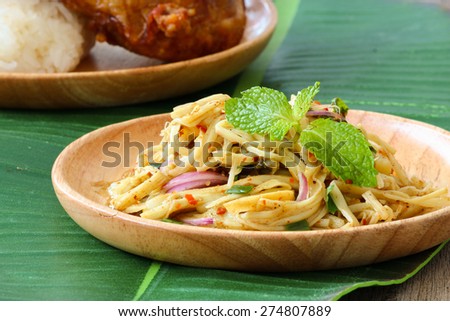 Thai style spicy bamboo shoot salad served in wooden plate on banana leaf