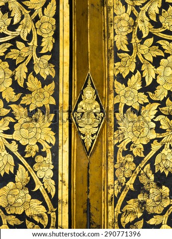 Thai classic art on temple door at Wat Rakhangkhositraram, Bangkok, Thailand. This use the gilding gold leave on the black lacquer method.