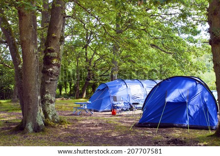 Big blue family tents in a forest camping ground