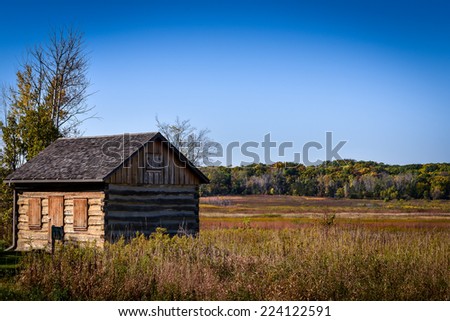 Old Wooden Cabin sitting in the field with blue sky