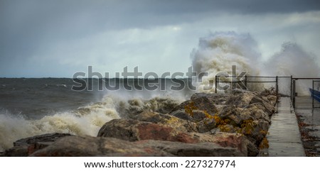 Crashing waves against rocks and pier