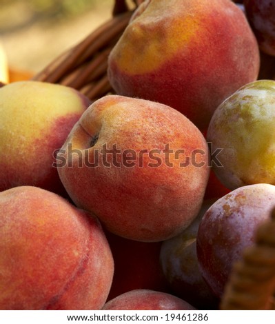 different fruits like plum and peach in a wooden basket