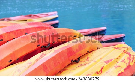Colourful yellow and red kayaks on turquoise sea water background