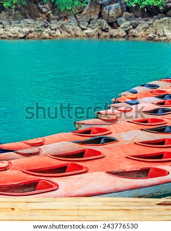 Colourful yellow and red kayaks on turquoise sea water background