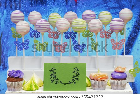 Delicious sweet cake-pops on sticks and cup-cakes