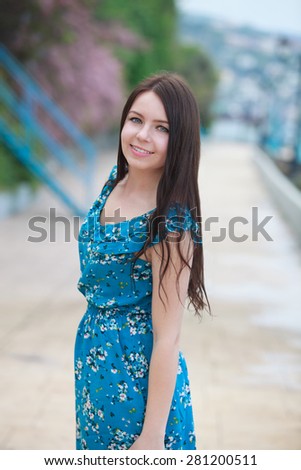 Young smiling white female with black long hair, summer outdoor look