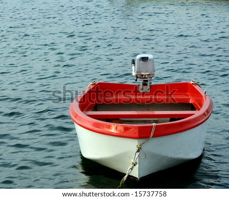 The red boat with motor overhead.