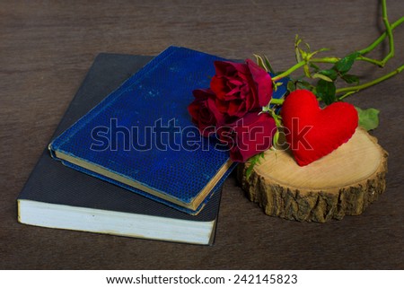 Roses on old books and glasses, small heart on timber still life.