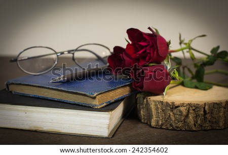 Roses on old books and glasses, small heart on wood timber