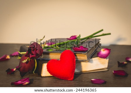 Roses on old books and small heart, vintage style.