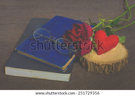 Roses on old books and glasses, small heart on wood timber, vintage style