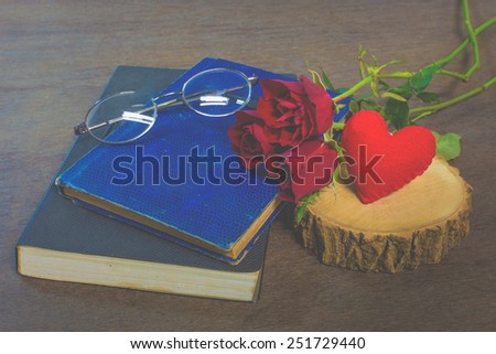 Roses on old books and glasses, small heart on wood timber, vintage style