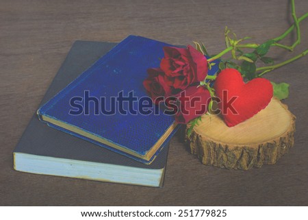 Roses on old books and glasses, small heart on timber still life., vintage style.