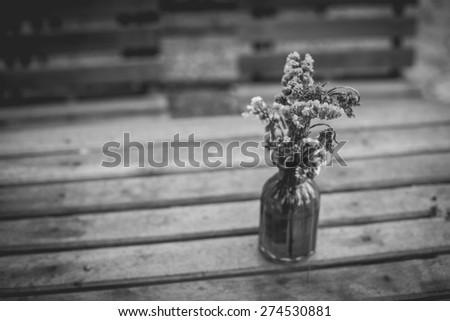 Lavender flowers in glass vase in vintage tone on wooden table.