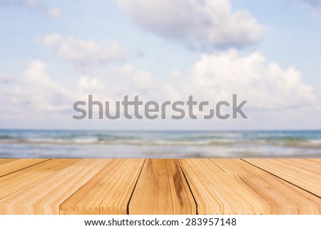 Selected focus Empty wooden deck table over sea background.