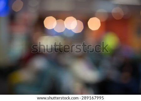 Blurred photo of an airport terminal with unrecognizible passengers passing by with luggage. Blurred background for topics of travel and transportation
