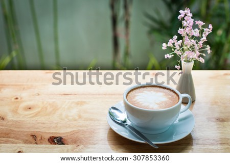 latte art coffee with flowers on wooden table, vintage and retro style.