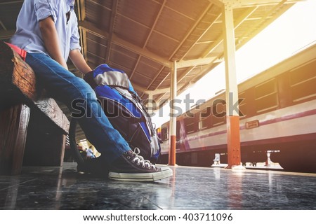 Portrait of a young man traveler waiting for train and travel bag.