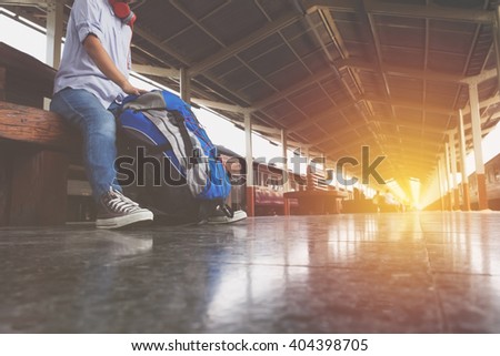 Portrait of a young man traveler waiting for train and travel bag.