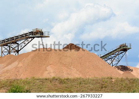 Soil and rocks being transported by conveyor belts at quarry