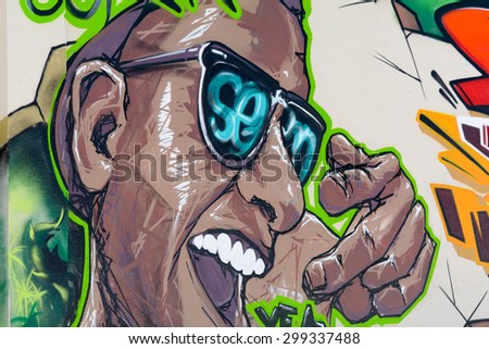 BORDEAUX, FRANCE - June 23, 2015: Graffiti art man smiling wearing sunglasses portrait on a fence in the city suburbs