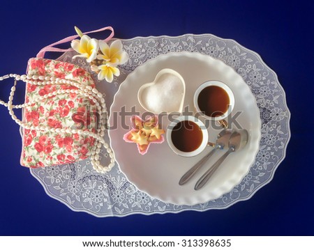 lovely mini double cup of hot tea with baked snack and sugar decorated in boutique and vintage style