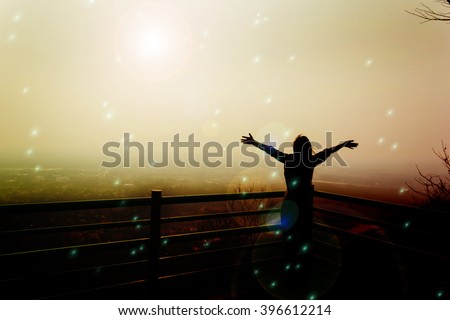 Silhouette back of women raising two arm embracing to sunlight and world in freedom concept , freedom feeling background