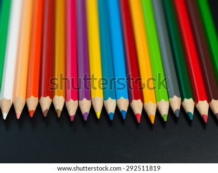 Bright and colorful pencils for school and kindergarten on black background