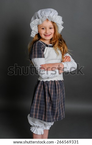 Girl in dress rustic vintage on a gray background crossed her arms and a smile