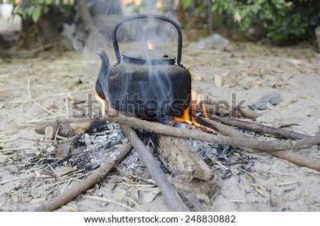 Boiling hot water with kettle on bonfire