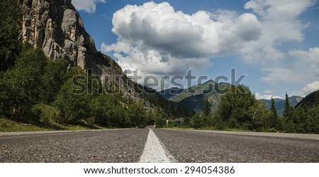 road in mountains on the background of clouds