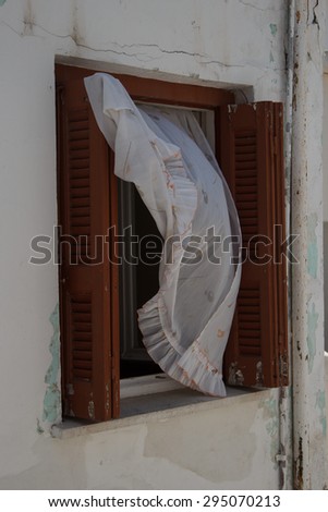 window with a curtain billowing in the wind