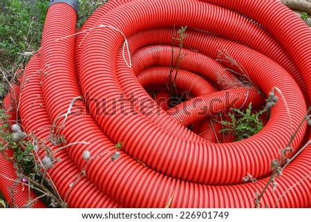 red plastic tube winded up  on grass