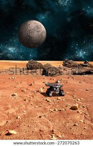 A robotic rover explores the surface of a rocky and barren alien world. A large cratered moon rises over the airless environment.  - Elements of this image furnished by NASA.