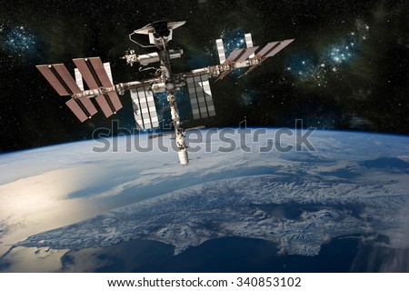 A depiction of the space shuttle docked at the international space station orbiting Earth. -  Elements of this image furnished by NASA