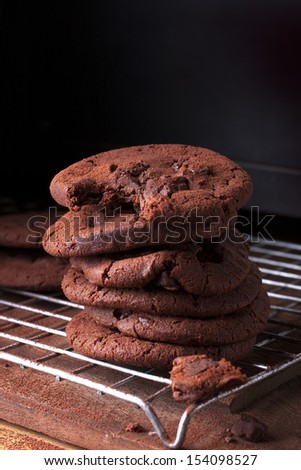Tall stack of soft chocolate chip cookie with a bite mark.