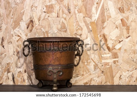 Antiques wine bucket made from brass on plywood wall background