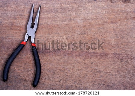 Pliers on wooden table with copy space