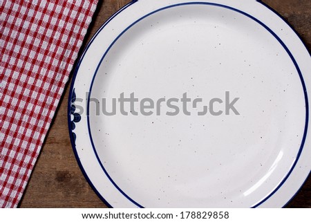 Plates and table cloth on wooden table with copy space